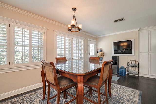 dining room featuring ornamental molding, dark wood-type flooring, and an inviting chandelier