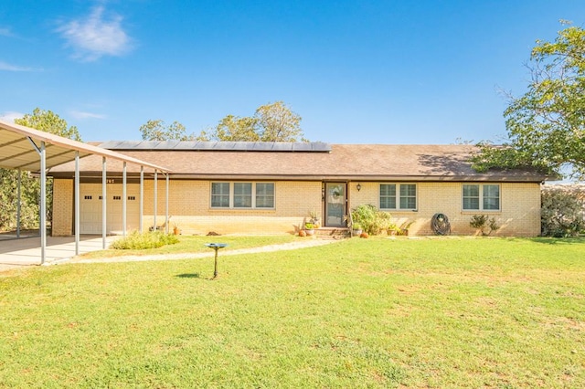 ranch-style house with a carport, solar panels, a garage, and a front lawn