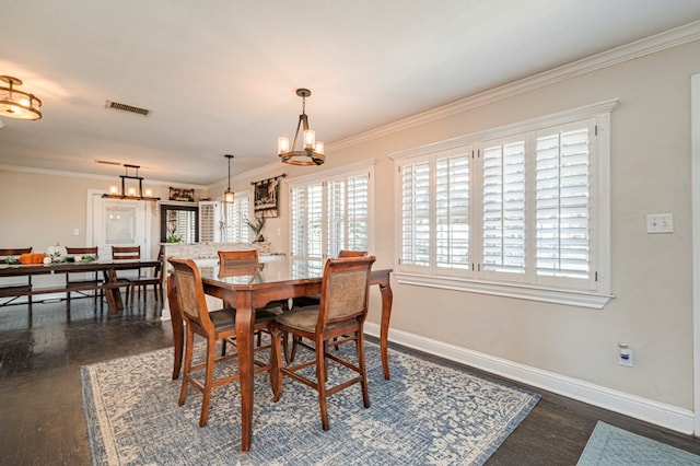 dining area featuring a chandelier, dark hardwood / wood-style floors, and ornamental molding