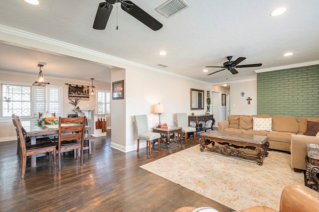 living room featuring crown molding, ceiling fan, brick wall, and dark hardwood / wood-style floors