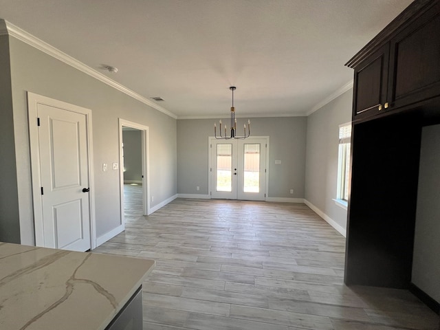 unfurnished dining area with crown molding, an inviting chandelier, light hardwood / wood-style floors, and french doors