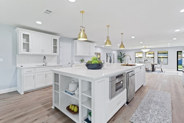 2208 Bedford Dr, Midland, TX 79701 - kitchen featuring a sink, visible vents, an island with sink, and white cabinets