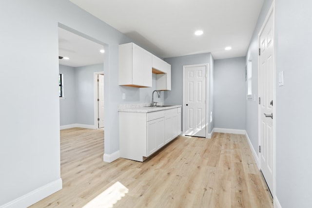 2208 Bedford Dr, Midland, TX 79701 - kitchen with white cabinetry, light countertops, baseboards, and a sink