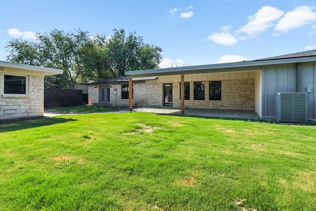 2208 Bedford Dr, Midland, TX 79701 - rear view of house with stone siding, a lawn, and board and batten siding