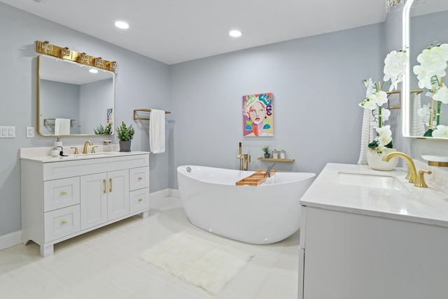 2208 Bedford Dr, Midland, TX 79701 - bathroom featuring a sink, a freestanding tub, two vanities, and recessed lighting