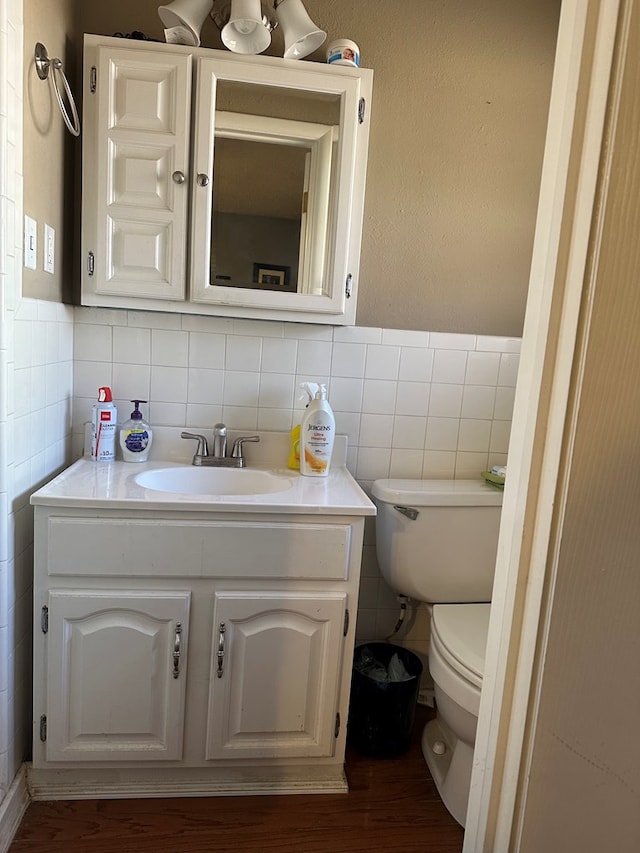 bathroom featuring vanity, toilet, and tile walls