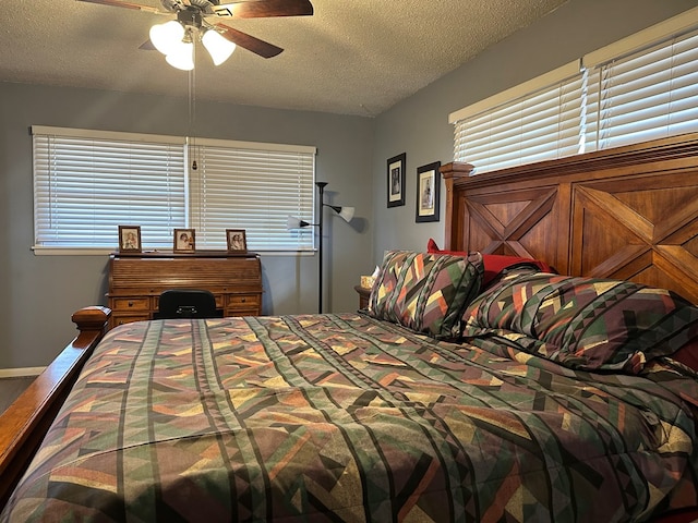 bedroom with ceiling fan and a textured ceiling