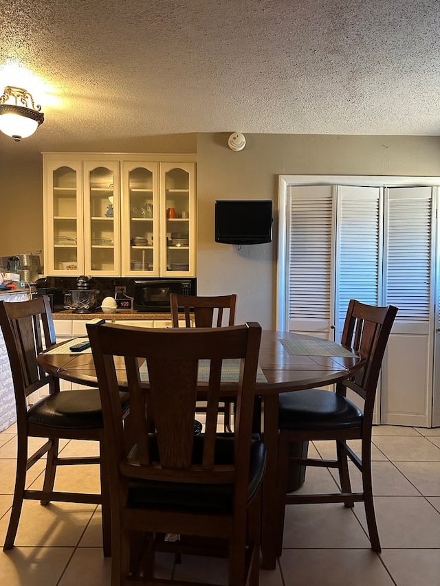 tiled dining area featuring a textured ceiling