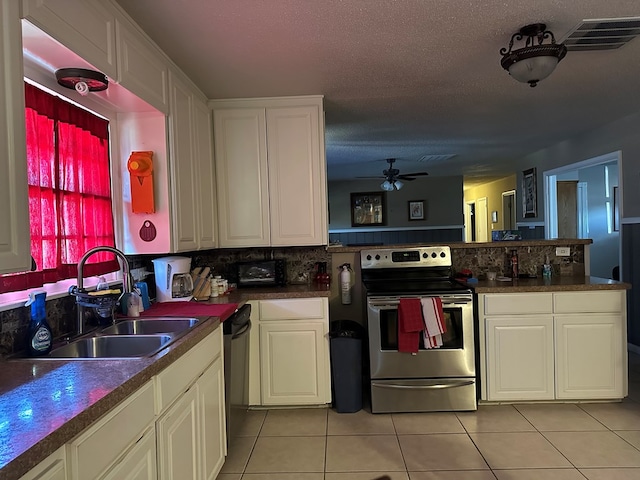 kitchen with white cabinetry, appliances with stainless steel finishes, sink, and light tile patterned floors