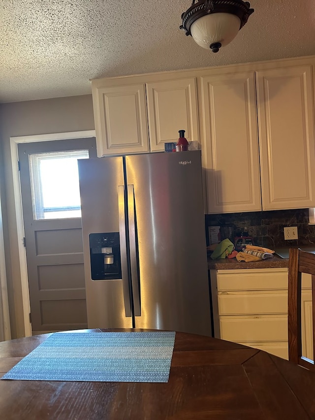 kitchen featuring white cabinets, a textured ceiling, and stainless steel fridge with ice dispenser