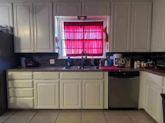 kitchen with light tile patterned flooring, white cabinetry, sink, decorative backsplash, and stainless steel dishwasher