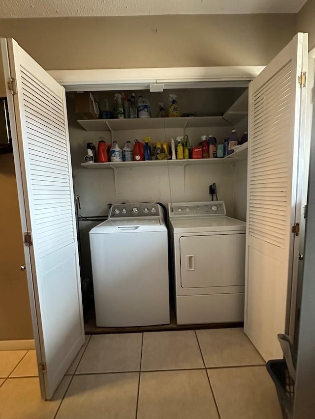 washroom with washing machine and dryer and light tile patterned flooring