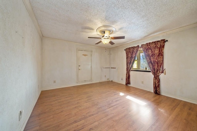 spare room featuring ornamental molding, light wood-type flooring, a textured ceiling, and a ceiling fan