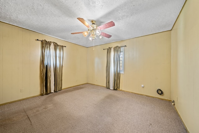 carpeted empty room featuring ceiling fan and a textured ceiling