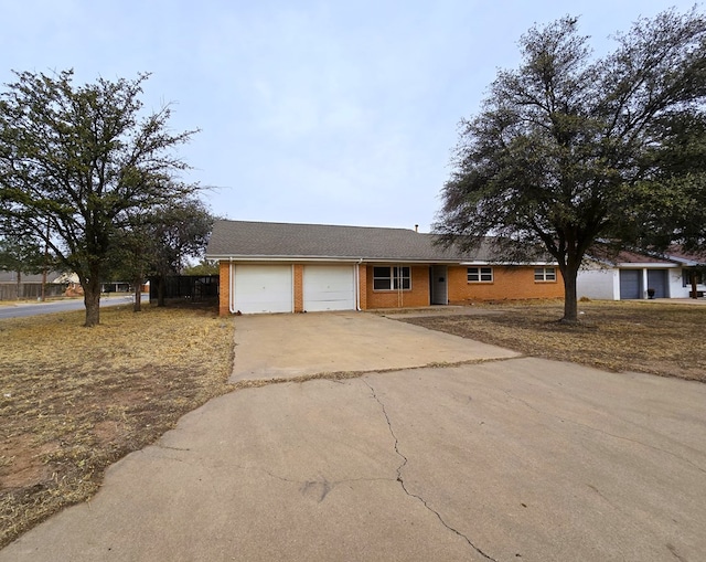 single story home featuring concrete driveway, brick siding, and an attached garage