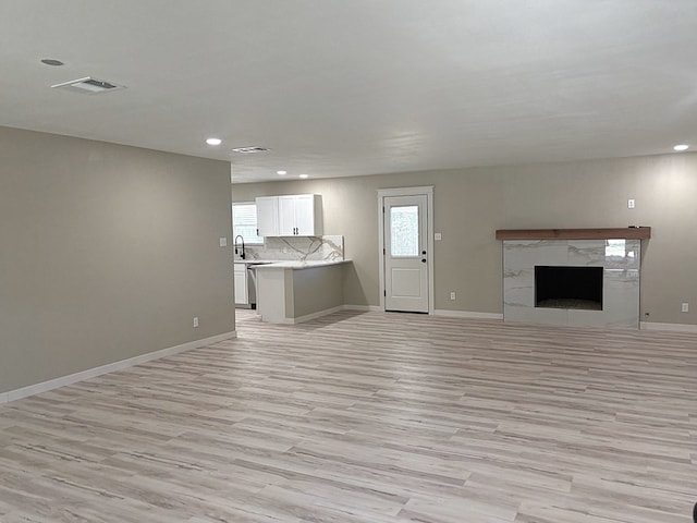 2612 Cimmaron Ave, Midland, TX 79705 - unfurnished living room featuring light wood-style floors, recessed lighting, and a high end fireplace