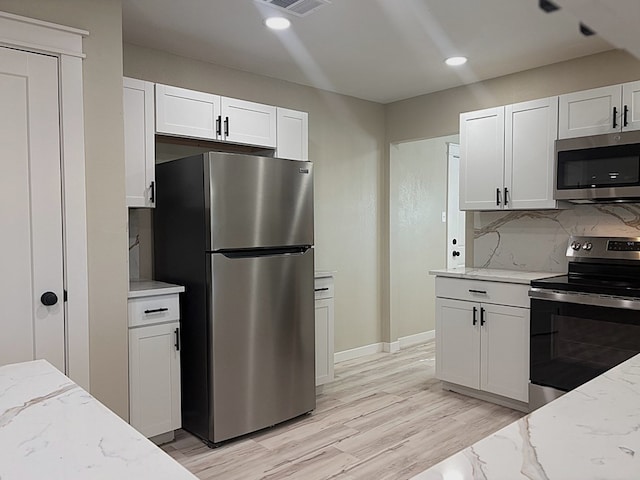 2612 Cimmaron Ave, Midland, TX 79705 - kitchen featuring stainless steel appliances, white cabinetry, light stone counters, backsplash, and recessed lighting