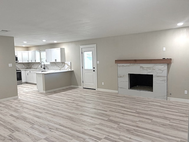 2612 Cimmaron Ave, Midland, TX 79705 - unfurnished living room with light wood-style floors, recessed lighting, and a fireplace