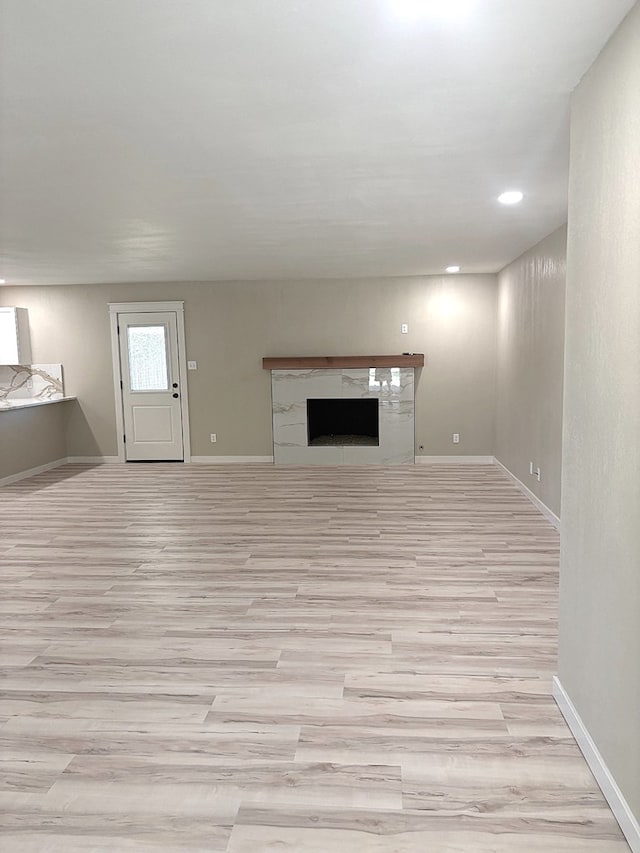 2612 Cimmaron Ave, Midland, TX 79705 - unfurnished living room featuring a fireplace, light wood-style flooring, and recessed lighting