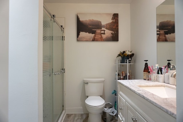 bathroom featuring walk in shower, vanity, toilet, and hardwood / wood-style floors