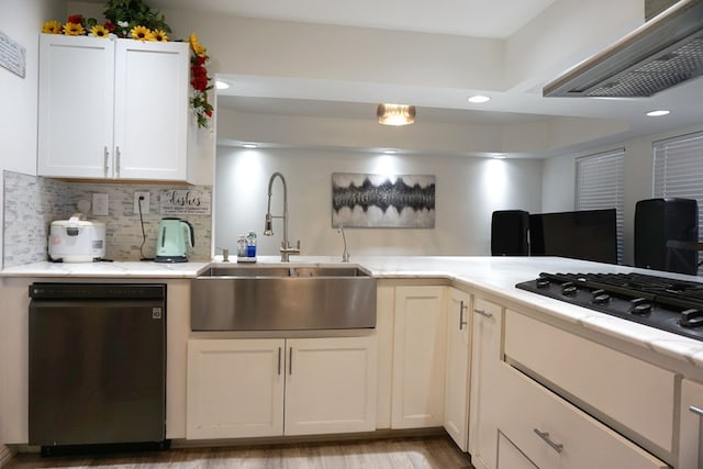 kitchen with white cabinetry, sink, backsplash, black appliances, and wall chimney exhaust hood