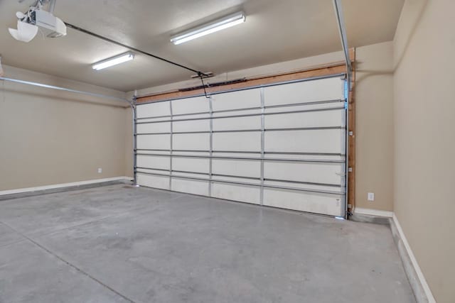 garage with baseboards and a garage door opener