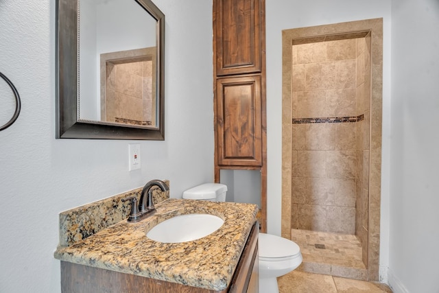 bathroom featuring toilet, a stall shower, vanity, and tile patterned flooring