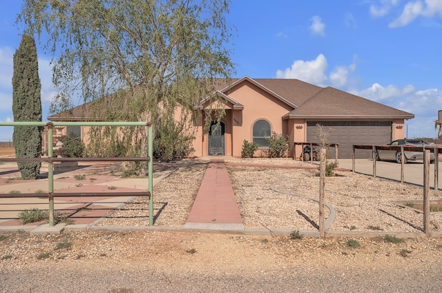 ranch-style home with driveway, stucco siding, and an attached garage