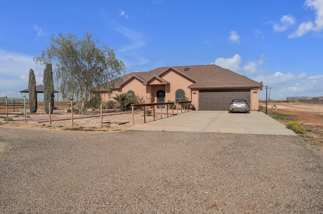 view of front of house featuring an attached garage, driveway, and stucco siding