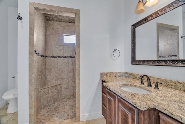 full bathroom featuring vanity, baseboards, tile patterned floors, toilet, and tiled shower