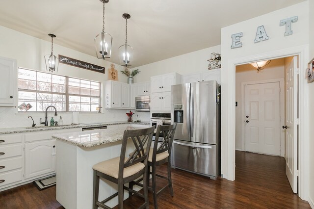 4902 Foxboro Ct, Midland, TX 79705 - kitchen with appliances with stainless steel finishes, a sink, decorative backsplash, and white cabinetry