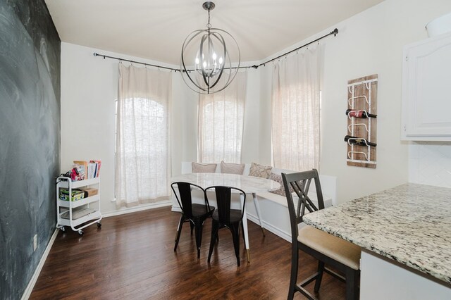 4902 Foxboro Ct, Midland, TX 79705 - dining area featuring a chandelier, dark wood-style floors, and baseboards