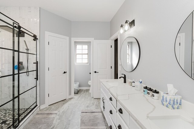 4902 Foxboro Ct, Midland, TX 79705 - bathroom featuring toilet, a stall shower, double vanity, marble look tile flooring, and a bidet