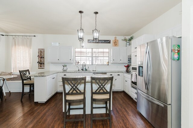 4902 Foxboro Ct, Midland, TX 79705 - kitchen featuring stainless steel appliances, a kitchen breakfast bar, a sink, and white cabinets