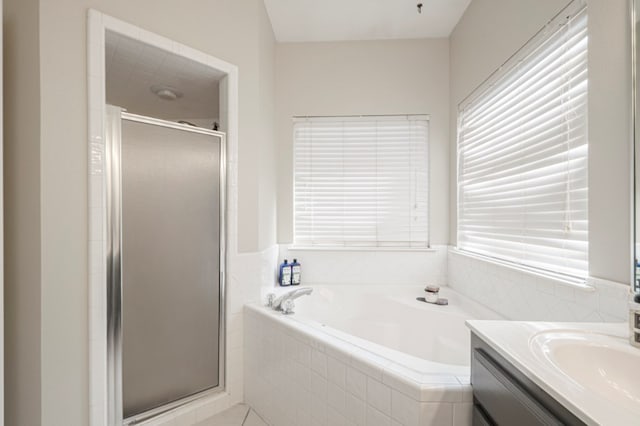 full bath featuring a garden tub, a shower stall, and vanity