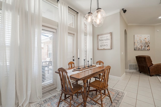 dining room with visible vents, arched walkways, crown molding, and light tile patterned flooring