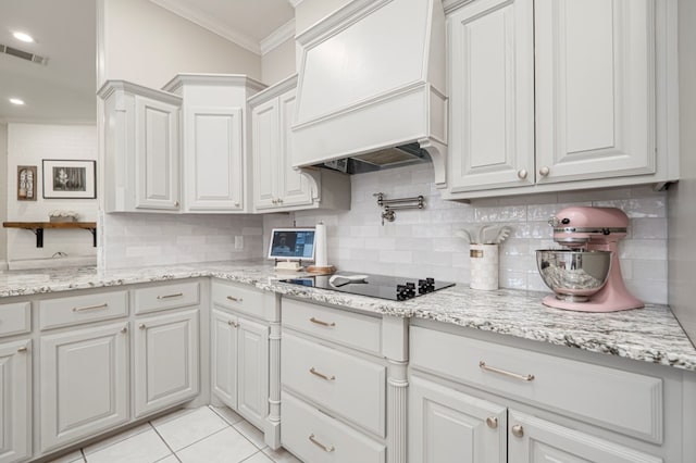 kitchen featuring visible vents, white cabinets, custom range hood, ornamental molding, and black electric cooktop