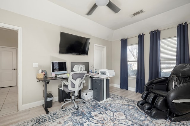 office with visible vents, vaulted ceiling, ceiling fan, wood finished floors, and baseboards