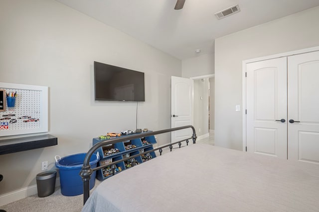 carpeted bedroom featuring baseboards, a closet, visible vents, and a ceiling fan