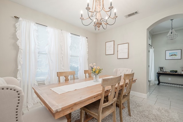 dining area featuring arched walkways, a notable chandelier, visible vents, light tile patterned flooring, and baseboards