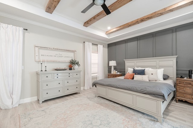 bedroom featuring a decorative wall, a ceiling fan, ornamental molding, light wood-type flooring, and beamed ceiling