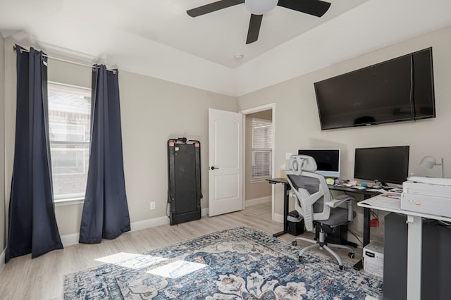 office area featuring a ceiling fan, light wood-type flooring, and baseboards