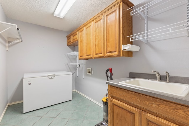 3402 Alicia Ct, Midland, TX 79707 - laundry area with cabinet space, hookup for a washing machine, light tile patterned floors, and a textured ceiling