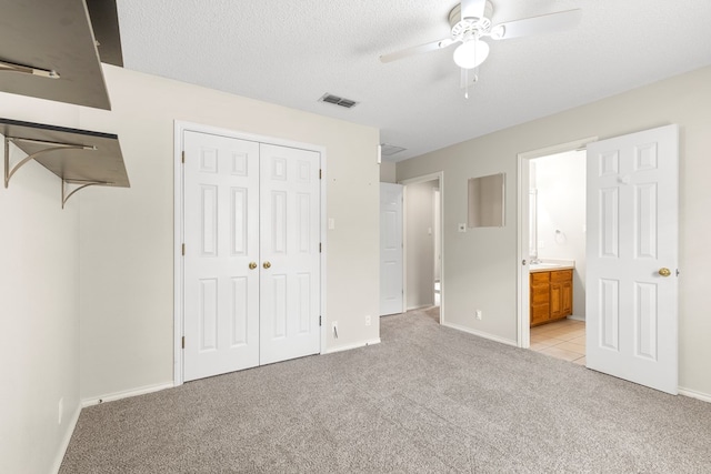 3402 Alicia Ct, Midland, TX 79707 - unfurnished bedroom with light colored carpet, connected bathroom, a closet, a textured ceiling, and a ceiling fan
