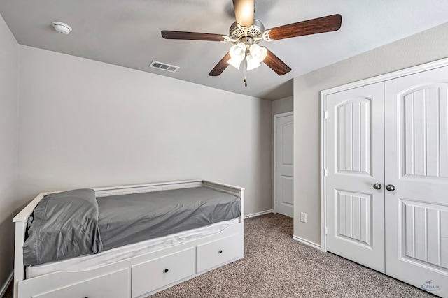 unfurnished bedroom with a closet, light colored carpet, and ceiling fan