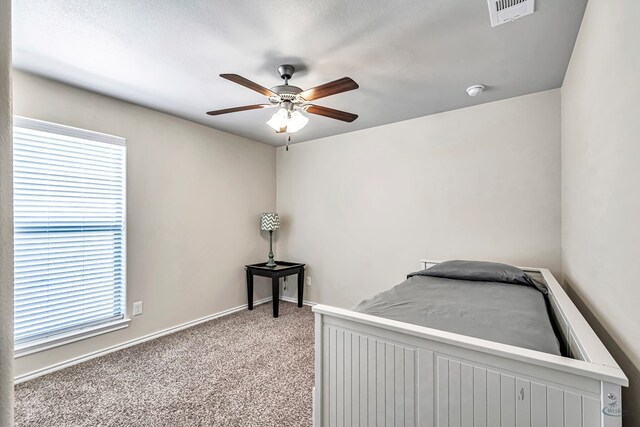 bedroom featuring carpet flooring, a textured ceiling, and ceiling fan