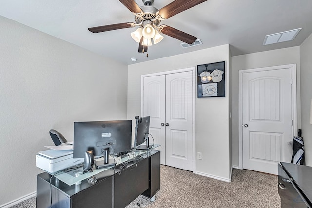 carpeted home office featuring ceiling fan