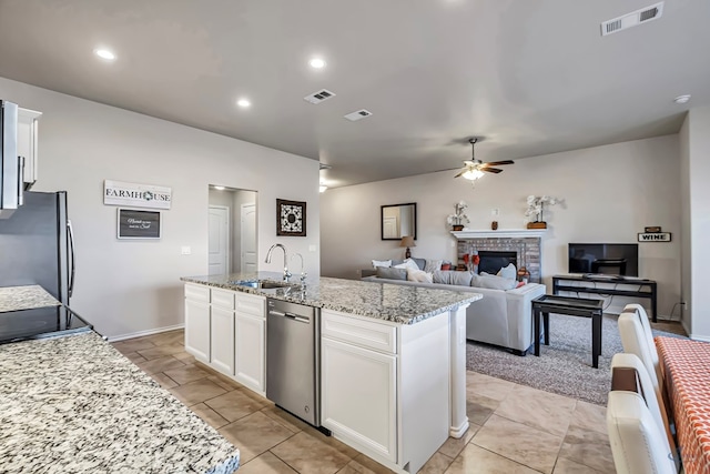 kitchen featuring white cabinetry, a center island with sink, stainless steel appliances, and sink