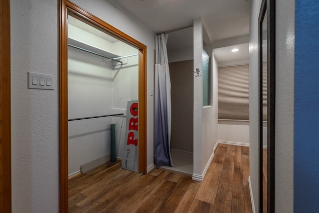 hall with hardwood / wood-style flooring and baseboards