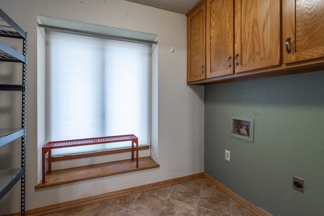 washroom featuring hookup for a washing machine, tile patterned flooring, electric dryer hookup, cabinet space, and baseboards